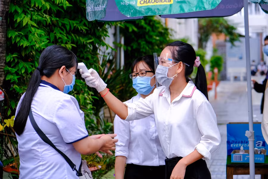 Các thí sinh được sát khuẩn tay và đo thân nhiệt trước khi vào khu vực thi.