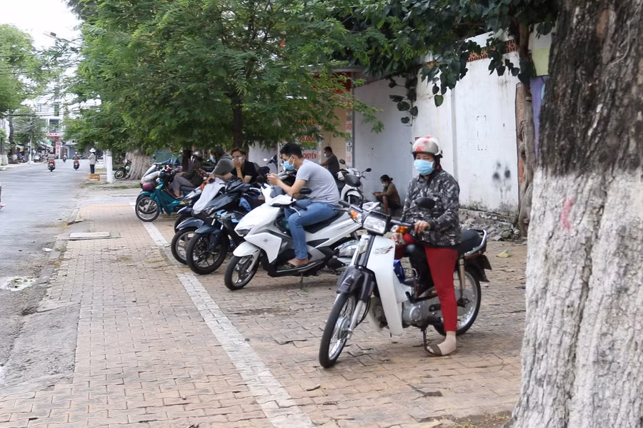 Phụ huynh đứng giãn cách trước điểm thi.