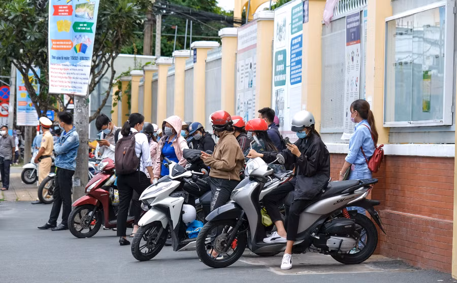Phụ huynh đứng đợi con ở cổng trường.