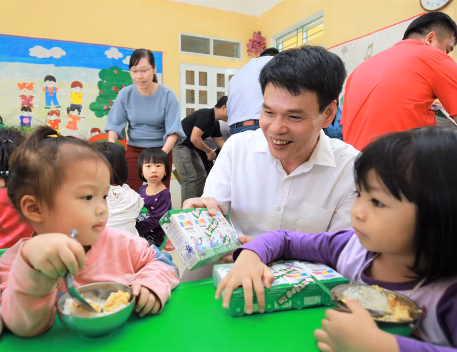  Ông Phạm Tuyên - Giám đốc Kinh doanh miền Bắc Công ty Cổ phần Sữa Việt Nam trao sữa cho các em nhỏ Trường mầm non Hoa Phượng, phường Cầu Thia, tỉnh Yên Bái.