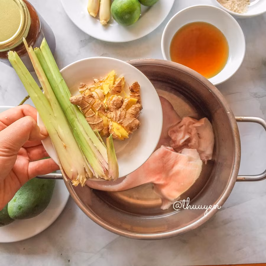 Thêm sả gừng vào nồi luộc chung với tai heo