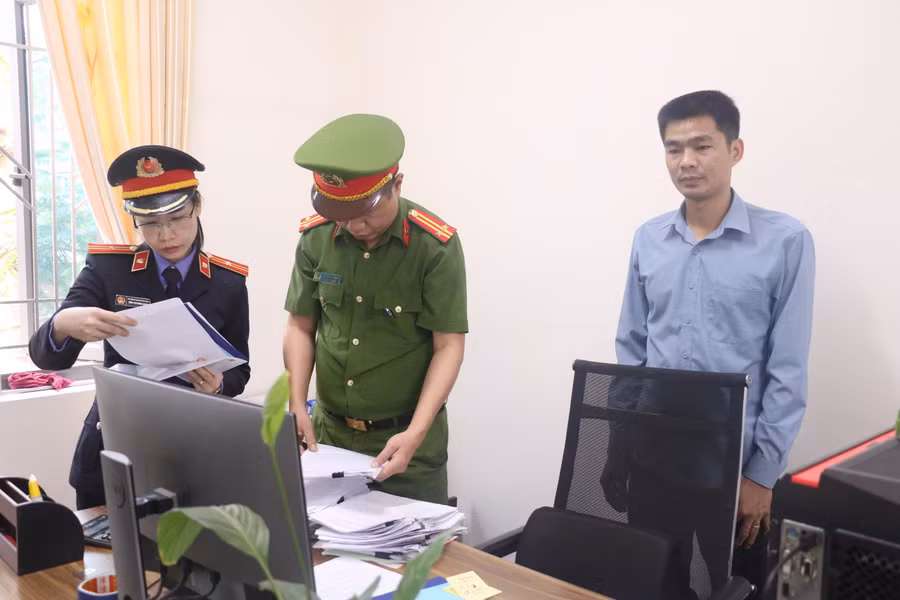 Lực lượng chức năng khám xét nơi làm việc của Phạm Văn Tài (bên phải). Lực lượng chức năng khám xét nơi làm việc của Phạm Văn Tài (bên phải).