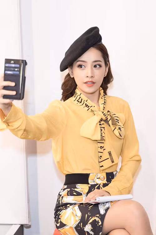 Điểm nhấn dải nơ in hoạ tiết thước kẻ giúp mẫu sơ mi màu vàng nhạt của Chi Pu trở nên bắt mắt hơn. dien-so-mi-chat-nhu-sao-viet-4