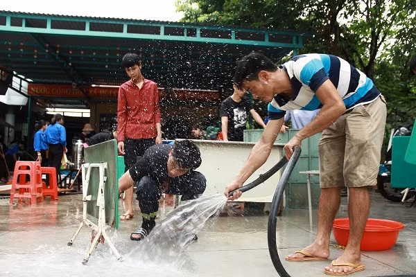 Lực lượng PCCC và tình nguyện viên giúp dọn dẹp trường học. Ảnh: Trúc Hân
