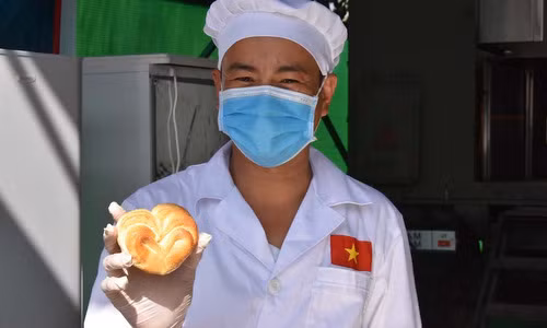 Thành viên đội Việt Nam với một chiếc bánh mì kem bơ tạo hình trái tim. Ảnh: QĐND.