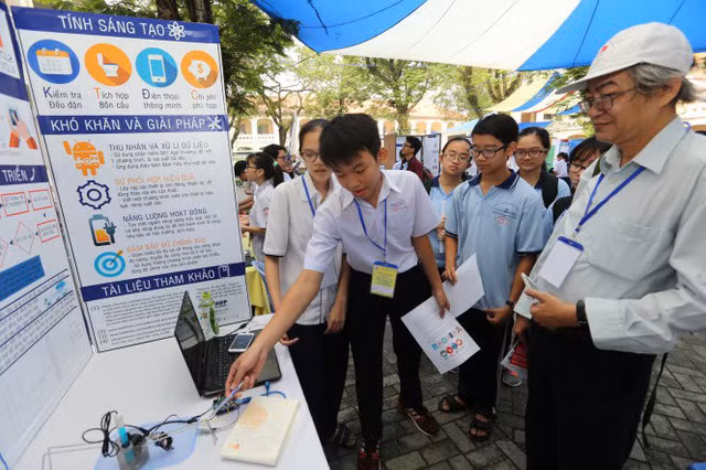 Học sinh Trường THPT chuyên Lê Hồng Phong (TP.HCM) giới thiệu đề tài "Bồn cầu cảnh báo sớm bệnh lý qua nước tiểu" tại vòng chung kết Cuộc thi khoa học kỹ thuật cấp TP - Ảnh: NHƯ HÙNG