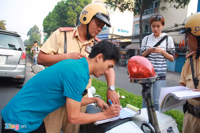 Các tài xế đều vui vẻ chấp nhận ký biên bản đóng phạt. Ảnh: An Huy. Tai xe ngo ngang khi CSGT ra quan xu phat nguoi khong that day an toan hinh anh 2