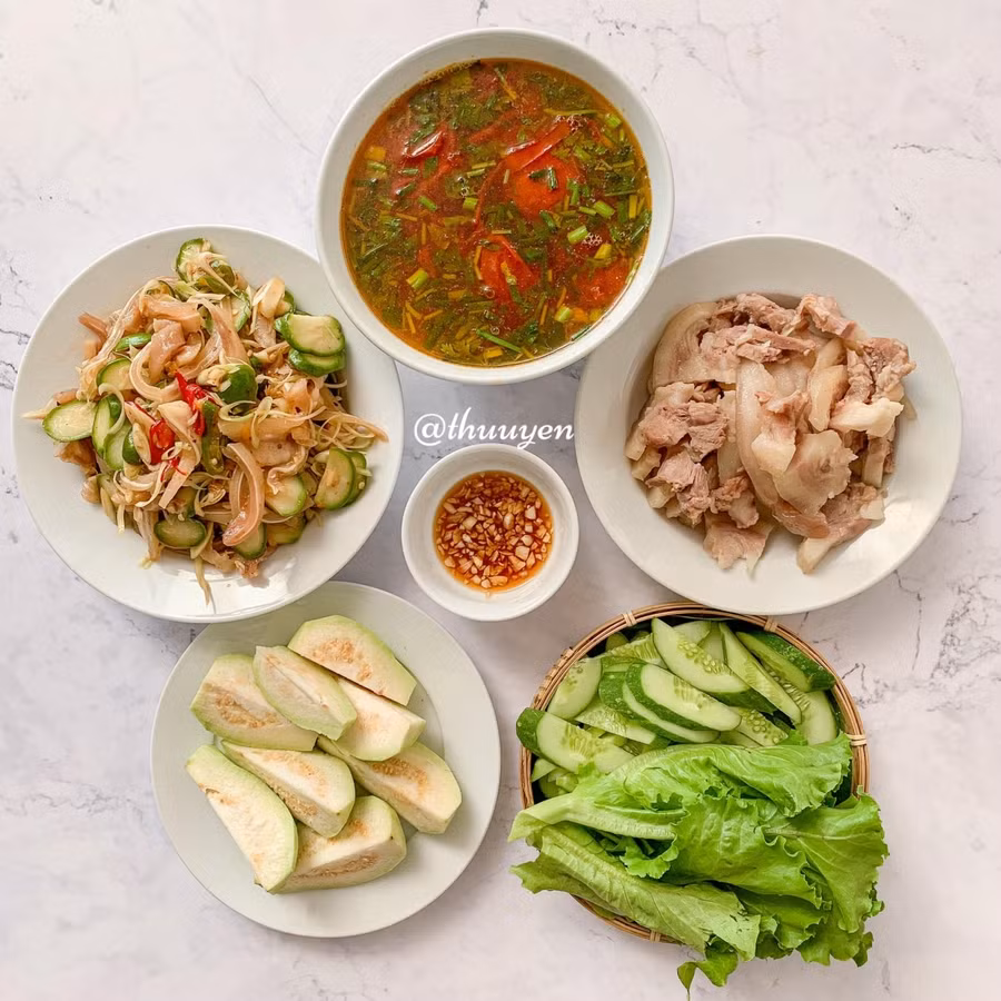 Canh cà chua, tai lợn trộn cóc, tai lợn luộc, rau sống.