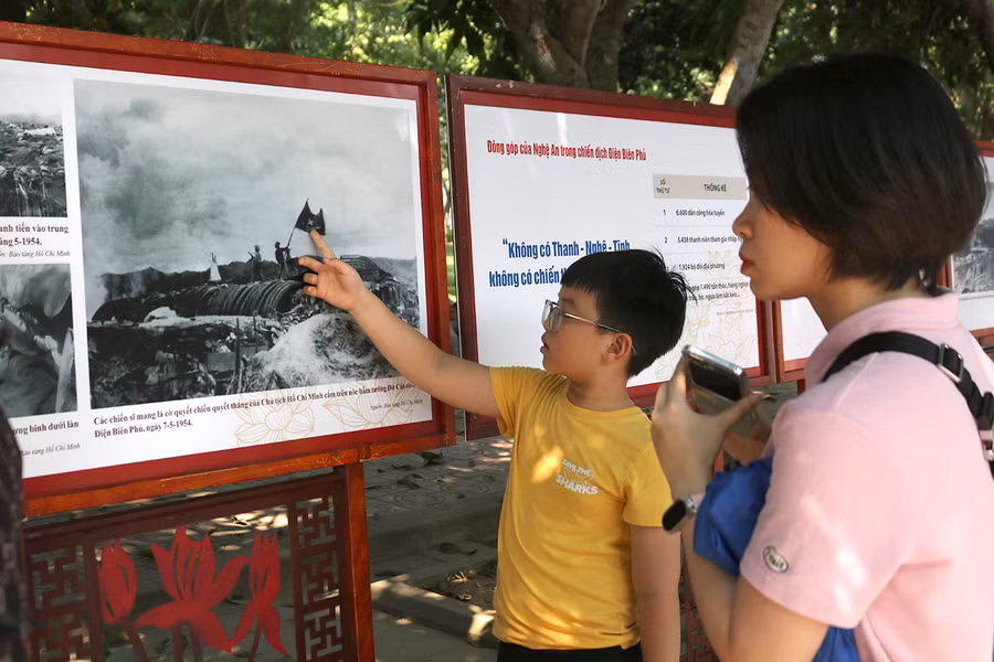 Trong khuôn viên Khu di tích Kim Liên, du khách và các em nhỏ còn được xem hàng trăm bức ảnh với chủ đề "Âm vang Điện Biên".