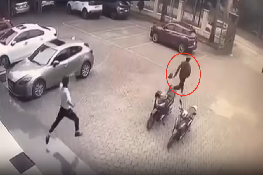 Tên cướp (khoanh đỏ) bỏ chạy sau khi bị nhân viên hô hoán. (Ảnh cắt từ video)