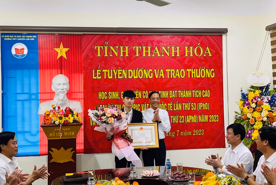 Ông Đầu Thanh Tùng tặng Bằng khen của Chủ tịch UBND tỉnh cho nam sinh Lê Viết Hoàng Anh. Ảnh: NTCC.