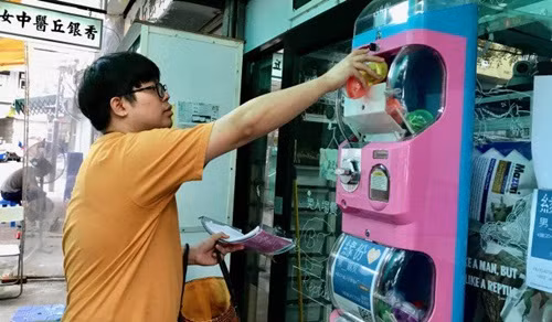 Ben Tang để những "quả bóng tình yêu" vào trong chiếc máy bántự động. Ben Tang để những quả bóng tình yêu vào trong chiếc máy tự động.