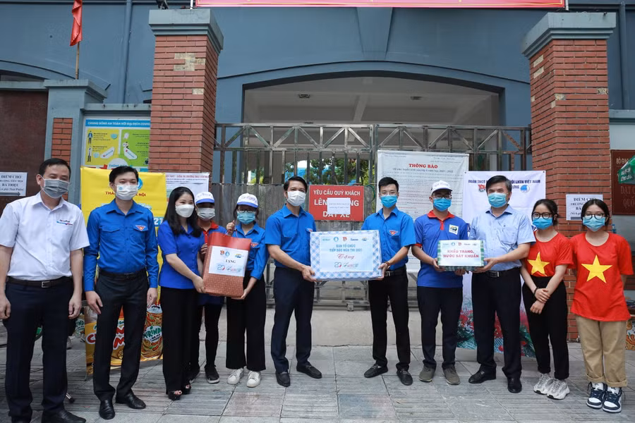 Anh Nguyễn Ngọc Lương và ông Bùi Văn Linh tặng quà cho đội hình tiếp sức mùa thi.
