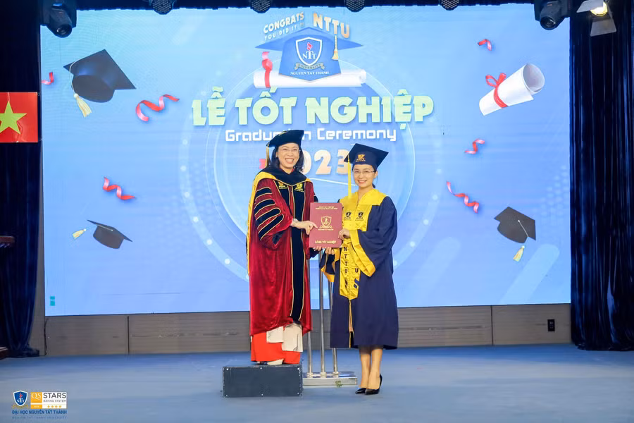 TS. Trần Ái Cầm - Hiệu trưởng Trường ĐH Nguyễn Tất Thành trao bằng cho 1 tân cử nhân.