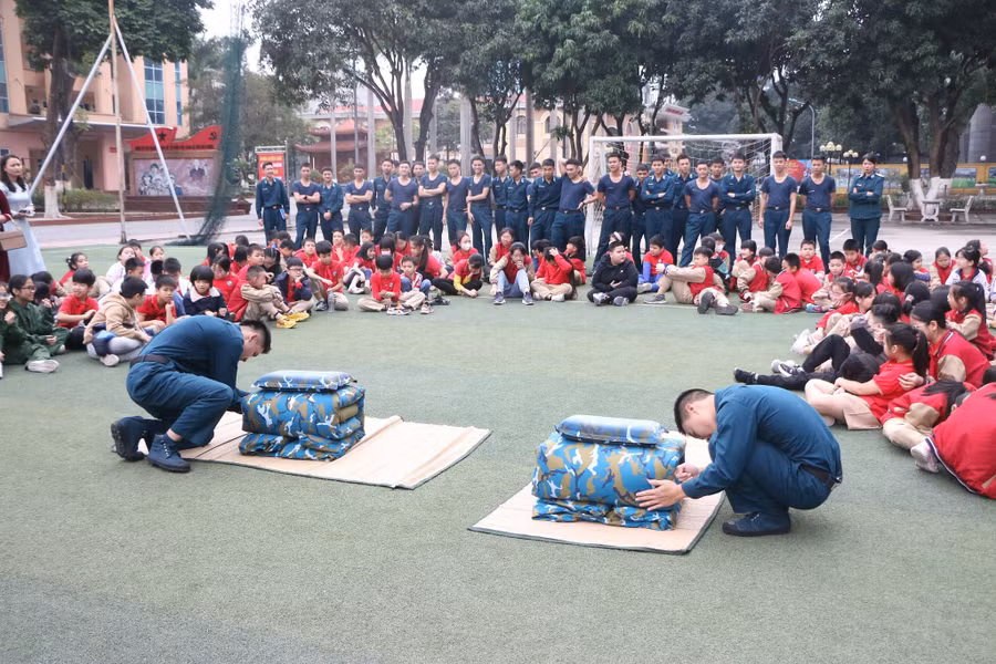 Các chiến sĩ thực hiện thao tác gấp chăn gối màn theo quy định trong quân đội để học sinh cùng theo dõi. Các chiến sĩ thực hiện thao tác gấp chăn gối màn theo quy định trong quân đội để học sinh cùng theo dõi.
