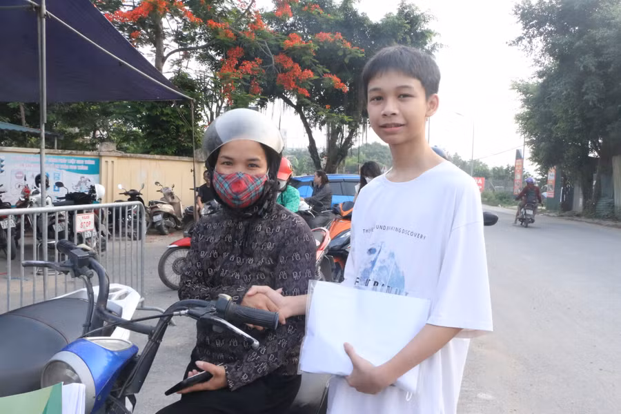Cái bắt tay truyền động lực của mẹ dành cho nam sinh Trần Thế Cường trước khi vào phòng thi.