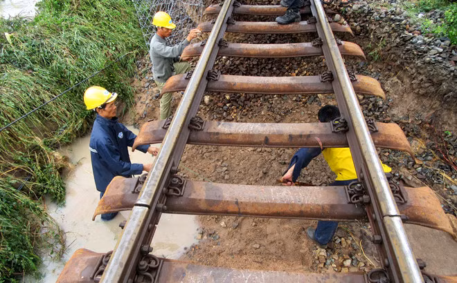 Nước lũ cuốn trôi phần móng đường sắt đoạn qua tỉnh Ninh Thuận làm tuyến đường sắt Bắc - Nam tê liệt. Ảnh:Tuấn Kiệt. Bao so 9 van vu giat sap nhieu nha, giao thong chia cat hinh anh 1