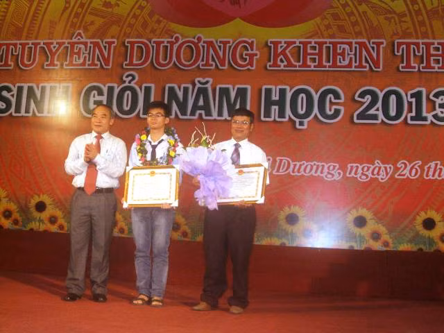 Thứ trưởng Nguyễn Vinh Hiển trao Bằng Khen cho thầy giáo Lê Thanh Bình và em Nguyễn Phan Quang Minh (HCB Tin học châu Á).