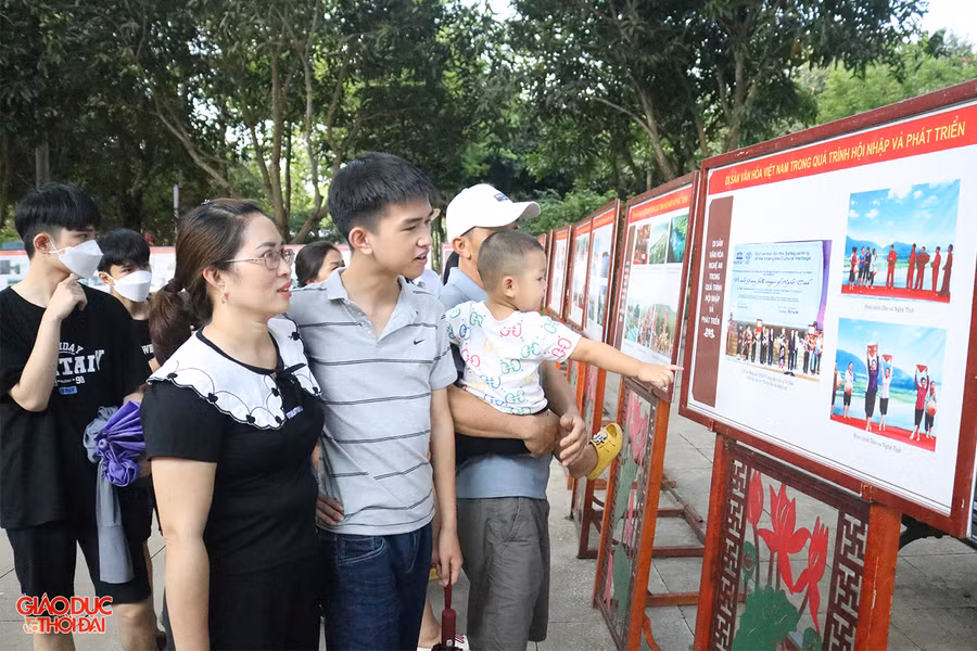 Du khách xem triển lãm ảnh chủ đề "Di sản văn hóa Việt Nam trong quá trình hội nhập và phát triển" tại Khu di tích Kim Liên. Ảnh: Phạm Tâm.