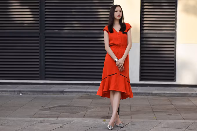 Váy màu cam cùng các chi tiết cài nút và thắt eo giúp bạn gái tỏa sáng trong nắng hè bởi sắc màu tươi vui và kiểu dáng đang được ưa chuộng ở mùa mốt mới. 5 set đồ xây dựng nét hiện đại cho nàng văn phòng