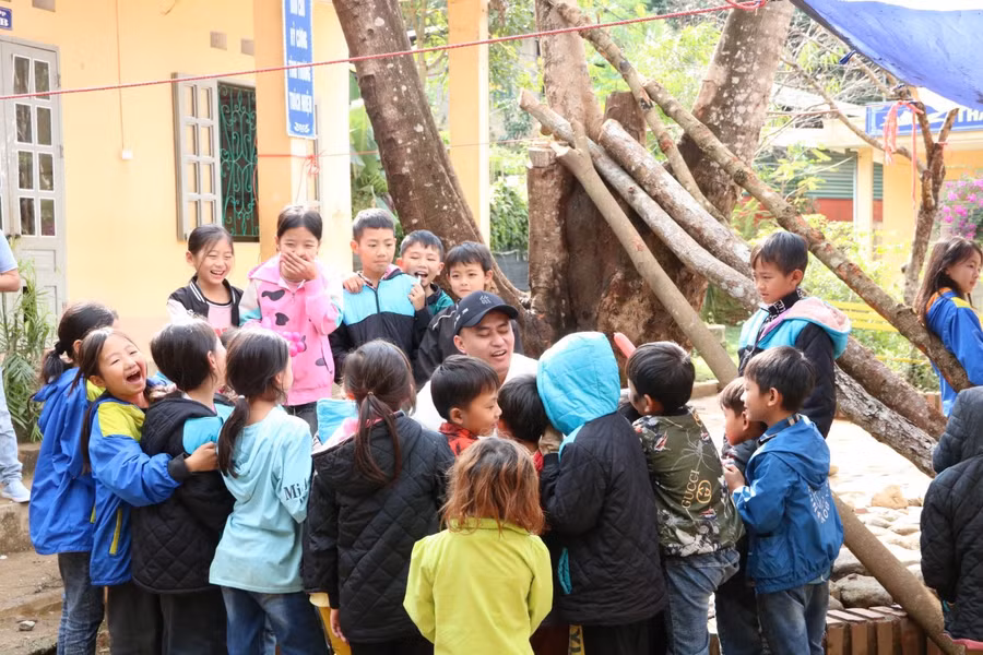 Học sinh vui vẻ với các thành viên trong đoàn từ thiện.