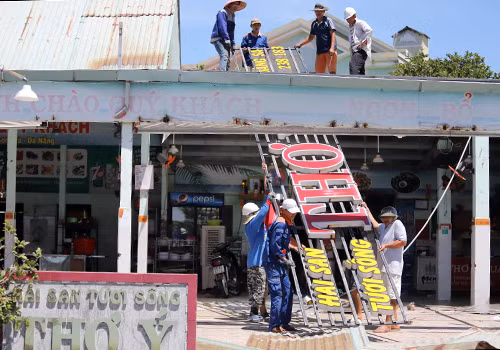 Công nhân tháo dỡ các hạng mục xây không phép tại nhà hàng hải sản Thơ Ý. Ảnh: Nguyễn Đông.