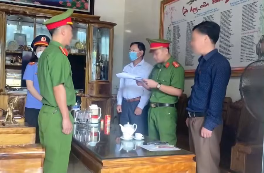 Công an huyện Quỳ Hợp tống đạt quyết định khởi tố bị can đối với Trương Văn Chính (áo trắng).