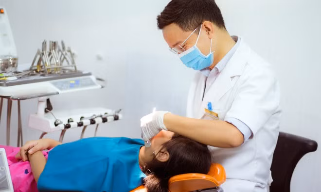 Theo bác sĩ Hoàng, cha mẹ cần tập cho trẻ thói quen chăm sóc răng miệng đúng cách từ khi còn bé: dùng chỉ nha khoa, chải răng, bỏ tật xấu như đẩy lưỡi, nghiến răng... Ảnh: T.P.