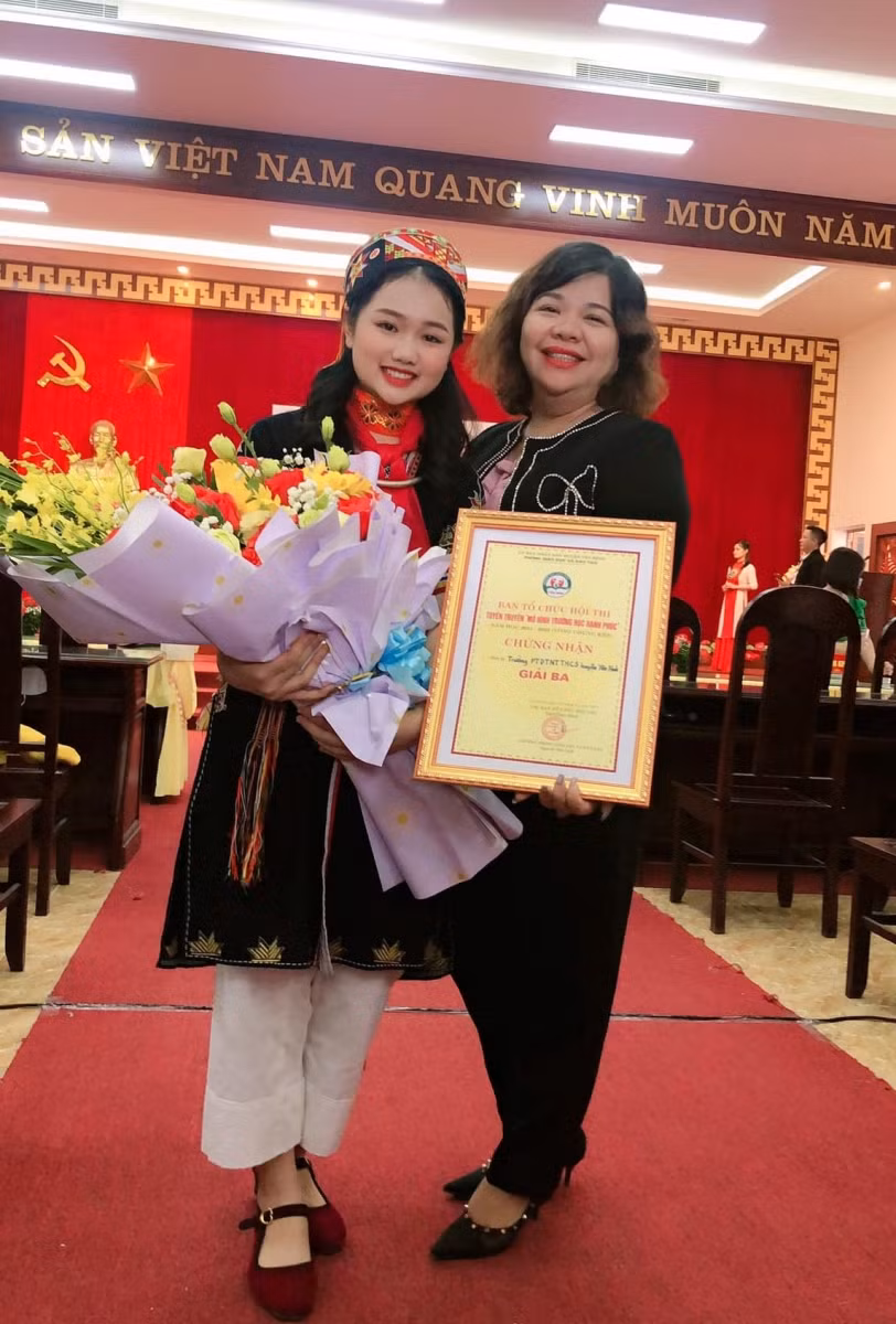Cô Bùi Vũ Ngọc Trâm-giáo viên trường PTDT nội trú THCS Yên Bình cùng học trò của mình trong ngày vui đón nhận giải thưởng tại một hội thi