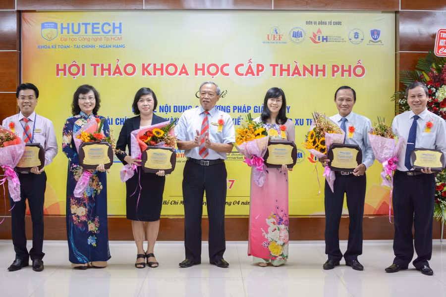 TS Kiều Tuân (giữa)- Chủ tịch HĐQT Trường ĐH Công nghệ TP Hồ Chí Minh - trao Kỷ niệm chương cho đại diện các trường trước phiên toàn thể