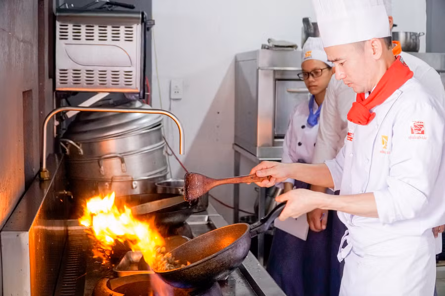 Học viên thực hành bếp nóng với sự hướng dẫn của giảng viên Nguyễn Văn Lộc