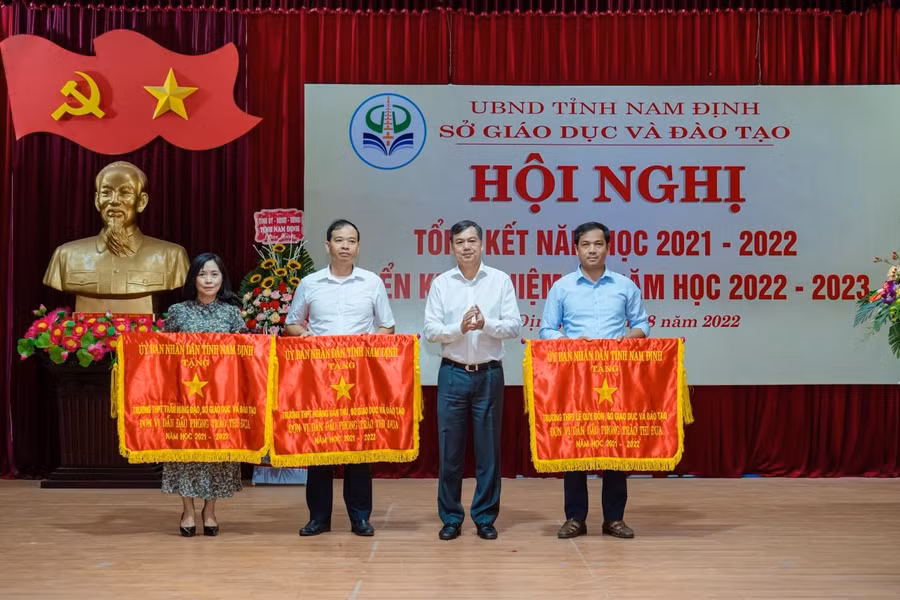 Phó Chủ tịch UBND tỉnh Trần Lê Đoài (thứ 2 từ phải sang) trao tặng cờ đơn vị dẫn đầu phong trào thi đua cho các tập thể có thành tích xuất sắc trong năm học vừa qua.