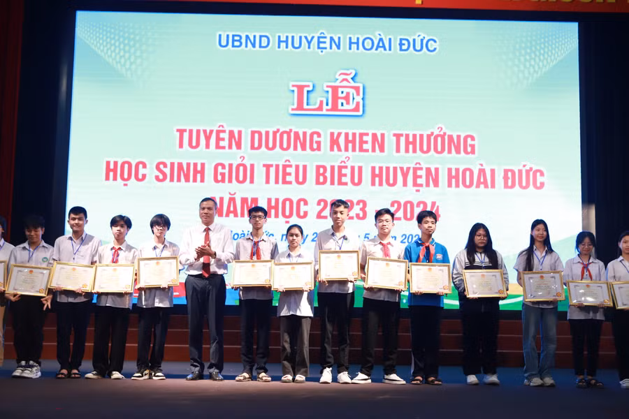 Phó Chủ tịch UBND huyện Hoài Đức Nguyễn Trung Thuận trao thưởng cho các em học sinh.