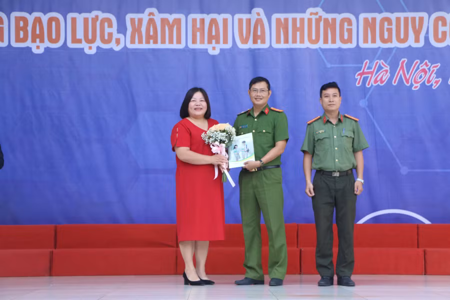 Từ trái qua: Cô Cao Thanh Nga - Hiệu trưởng nhà trường tặng hoa cho hai vị khách mời là Thiếu tá Lê Mạnh Cường và Thiếu tá Nguyễn Hữu Huy.