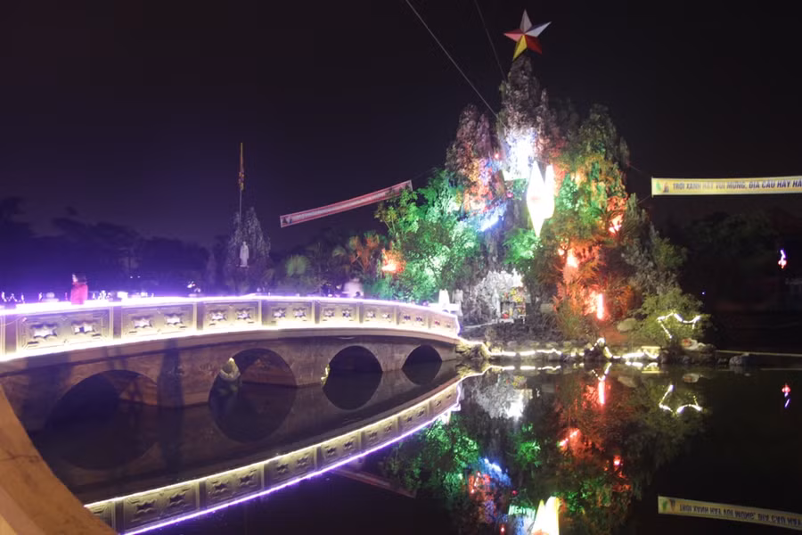 Mọi người đi thăm hang đá ở giữa hồ nước tại Giáo xứ Yên Đại, TP Vinh
