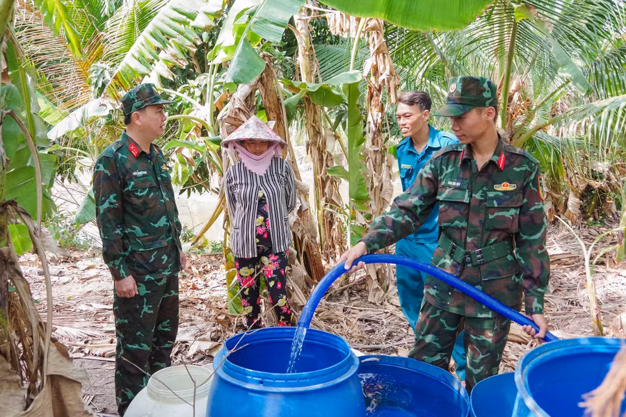 Các chiến sĩ bộ đội và dân quân tự vệ cấp nước cho người dân.