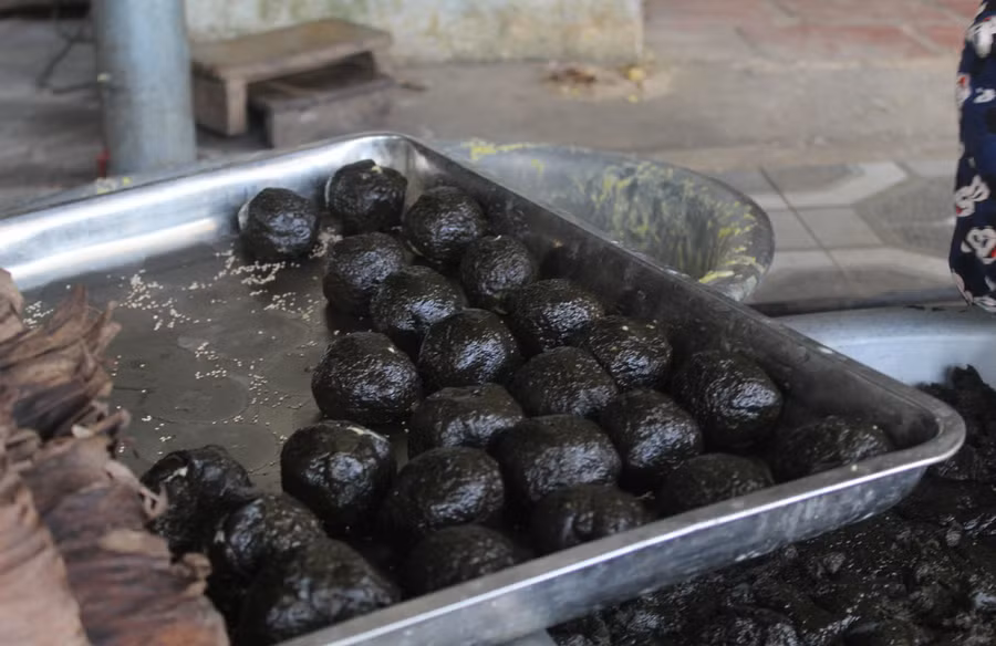 Bao bọc bên ngoài là bột nếp xay nguyễn hòa cùng bột lá gai tạo thành lớp vỏ màu đen óng ánh. Ảnh: LT. Bao bọc bên ngoài là bột nếp xay nguyễn hòa cùng bột lá gai tạo thành lớp vỏ màu đen óng ánh. Ảnh: LT.
