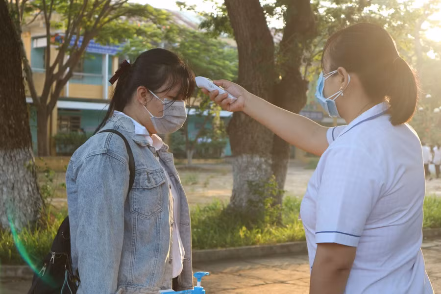 Thí sinh được đo thân nhiệt trước khi di chuyển về phòng thi.