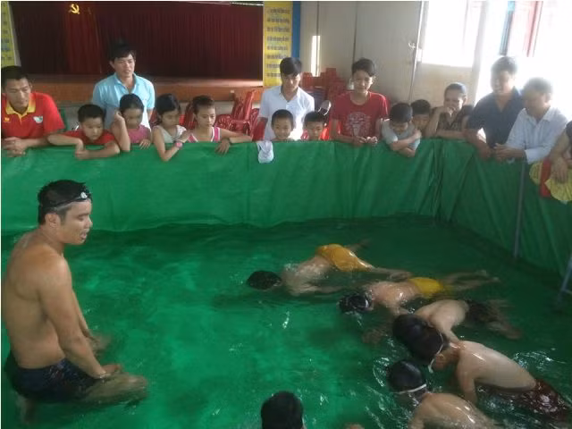 Các em học sinh học bơi tại bể bơi mini