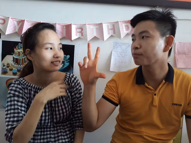 Hai vợ chồng giao tiếp bằng ngôn ngữ cử chỉ, giao tiếp với khách hàng thông qua cây viết và cuốn sổ