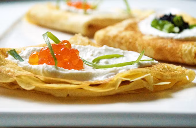 Bánh kếp Bánh kếp Nga có 2 loại phổ biến là Blini và Syrniki. Bánh kếp Blinicó phần bột mỏng, xuất hiện trên bàn ăn của người Nga ở mọi dịp quan trọng, thường được làm bằng kiều mạch, ăn kèm với cá hồi hun khói,hoặc trứng cá muối cá tầm truyền thống,kem, mứt và sữa đặc. Syrniki có phần bột dày hơn, thường dùng trong bữa sáng hoặc tráng miệng. Món bánh này thường được người Nga dùng kèm các loại mứt trái cây, sữa đặc, mật ong và kem.Đến Nga, bạn có thể thưởng thức món bánh đặc trưng này ở bất cứ con phố nào. Đến Nga xem World Cup đừng quên ăn các món trứ danh - 4
