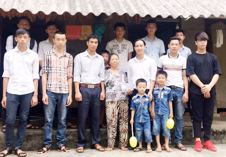 Thầy giáo Nguyễn Quang Đại (thứ 3 từ phải sang) trao quà cho người nghèo khi tổ chức thiện nguyện