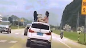Thót tim cảnh hai con nhỏ chơi trên nóc ô tô chạy tốc độ cao