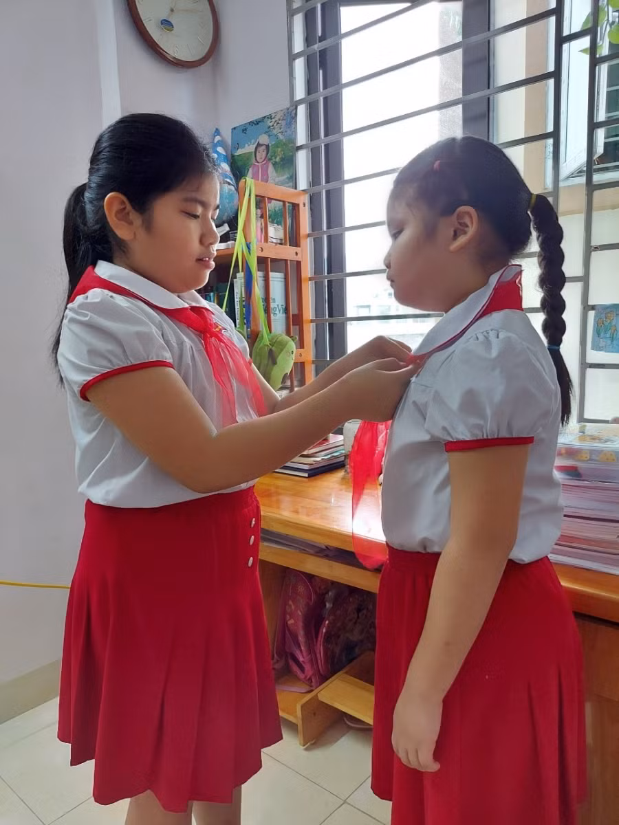 Các em dậy từ sớm và chuẩn bị đồng phục, khăn quàng đỏ thắm chuẩn bị dự lễ khai giảng trực tuyến. Ảnh: Phụ huynh cung cấp.