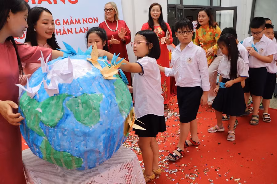 Các học sinh trường Tiểu học, Mầm non Tân Thời Đại gắn những chiếc hạc giấy xinh ghi những ước mơ trước thềm năm học mới lên quả địa cầu.