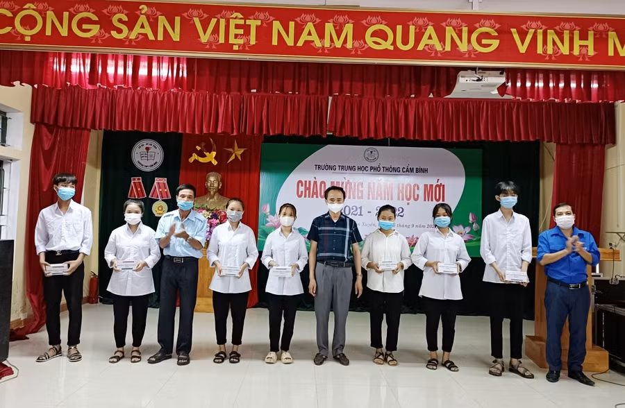 Thầy Nguyễn Văn Quang - Hiệu trưởng Trường THPT Cẩm Bình trao điện thoại cho các học sinh.