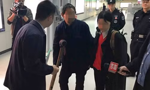 Phóng viên Trung Quốc phỏng vấn hai người hành nghề ăn xin tại ga tàu điện ngầm. Ảnh: SCMP.