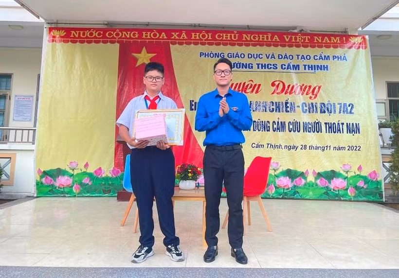 Em Hoàng Mạnh Chiến (trái) được nhà trường tuyên dương, khen thưởng ngay tại trường vào chiều 28/11. Ảnh: TG.