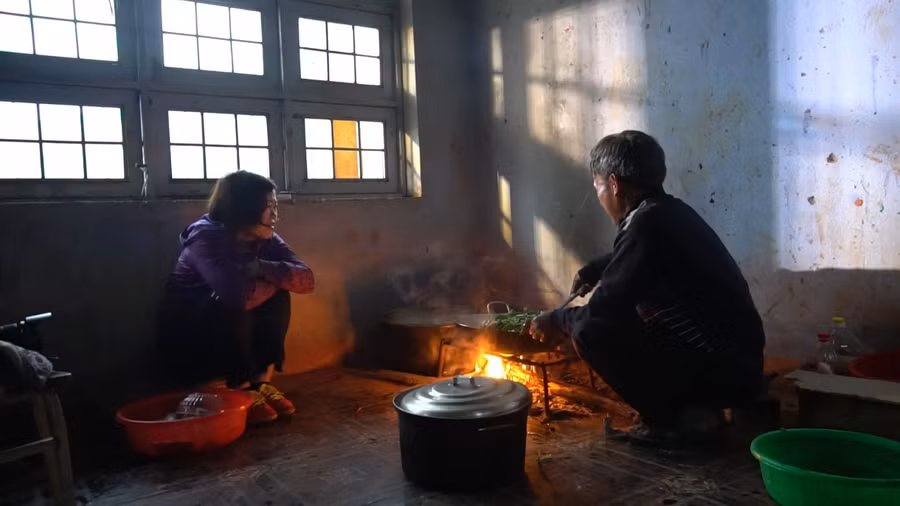 Nhà báo Lê Thị Hương bên bếp ăn của thầy A Phiên - Trường Dân tộc bán trú Tiểu học, THCS xã Tu Mơ Rông, huyện Tu Mơ Rông, tỉnh Kon Tum.