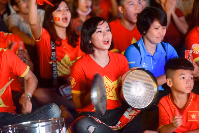 Một cổ động viên tạo tiếng động miệng hô vang Việt Nam vô địch.